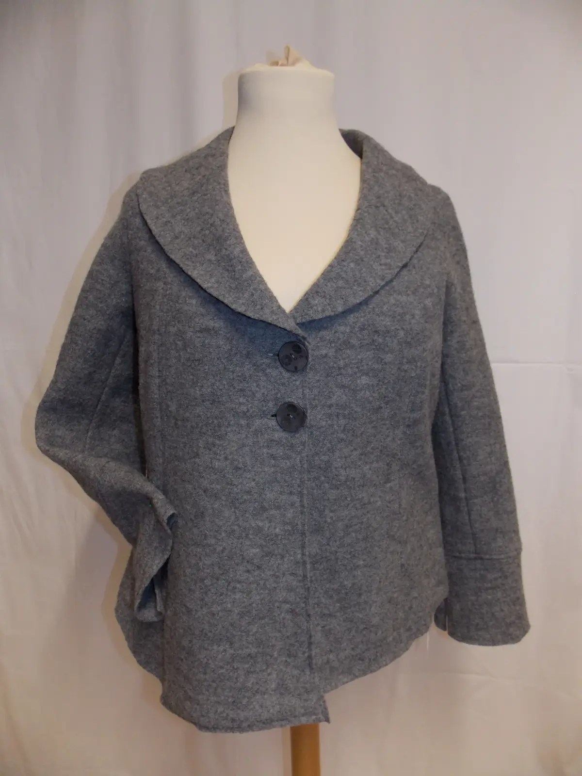 Graue Jacke mit Schalkragen auf der Schneiderbüste