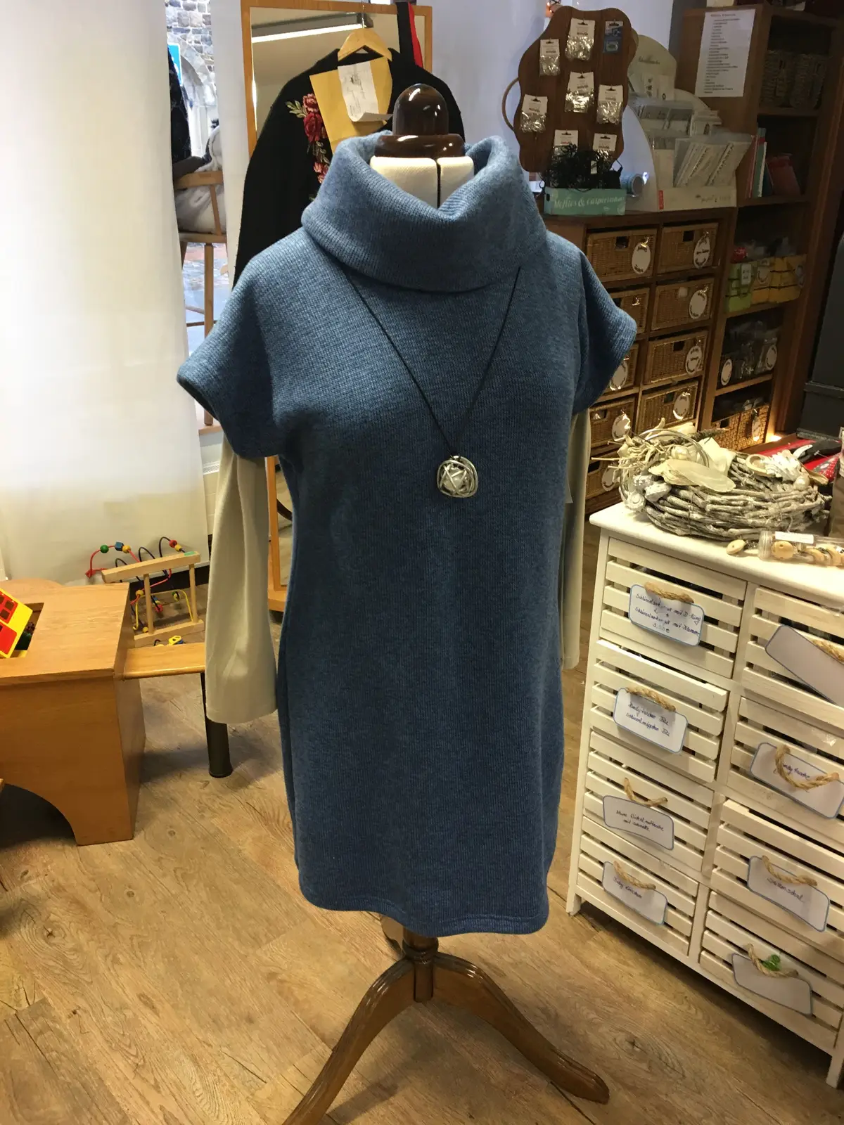 Blaues Kleid mit hohem Kragen auf der Schneiderbüste