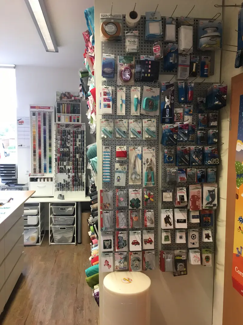 Wand mit Garnen, Nadeln und Kurzwaren im Atelier