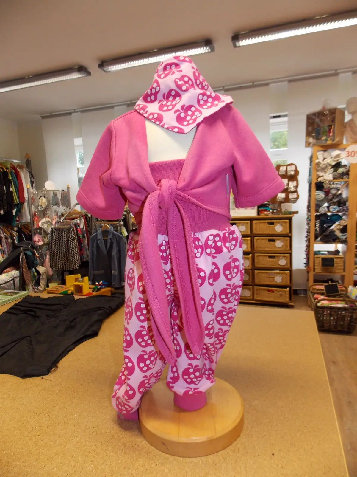 Rosa Kinderoutfit mit gemusterter Hose auf dem Ständer
