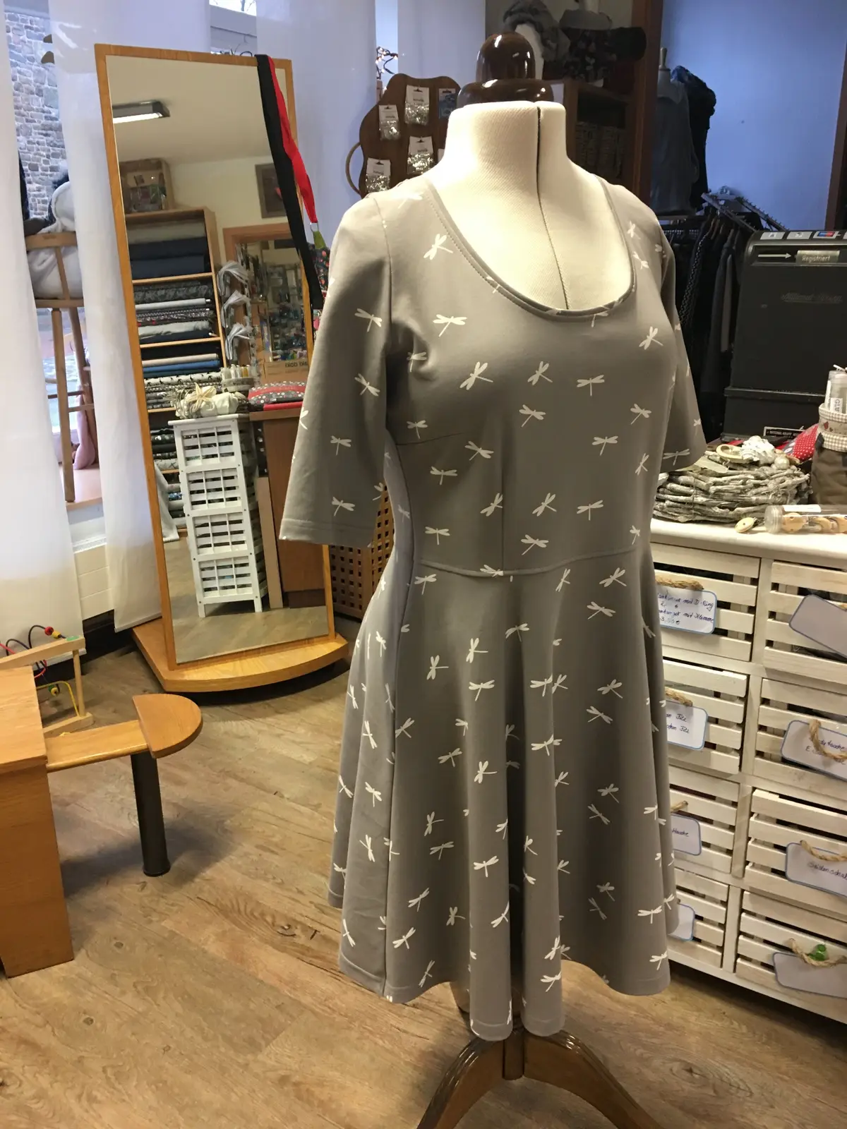 Graues Kleid mit kleinem Muster auf der Schneiderbüste